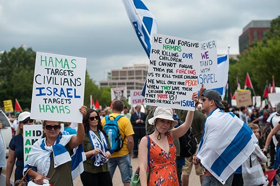 Участники произраильского митинга с плакатами: «Цель “Хамас” — мирные граждане, цель Израиля — “Хамас”»; «Мы можем простить “Хамас” за убийство наших детей. Мы не можем простить “Хамас” за то, что они принуждают убивать их детей. У нас будет мир только тогда, когда они будут любить своих детей больше, чем ненавидеть нас. Поддержи мир вместе с Израилем». Вашингтон. 2 августа 2014. EASTNEWS